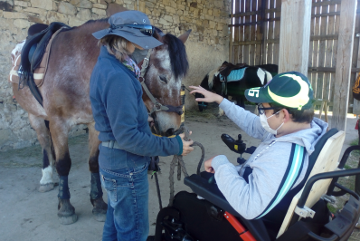 jeune handicapé en fauteuil roulant fait la connaissance d'un cheval en compagnie de marie-noëlle gachet