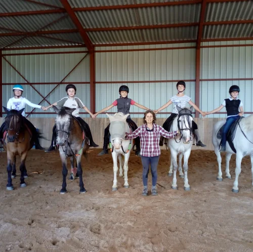 marie-noëlle gachet, enseignante d'équitation, entourée par ses élèves à cheval