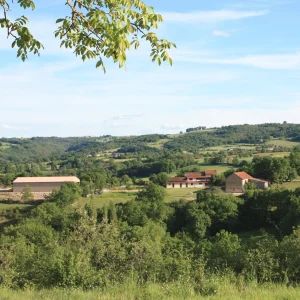 vue lointaine montrant la ferme de Saint-Gauzy avec ses différents bâtiments sur la droite ainsi que le manège sur la gauche