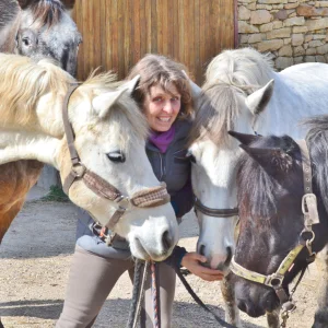 photo de marie-noëlle gachet entourée par quatre chevaux