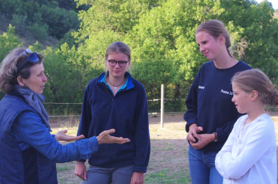 Marie-Noëlle Gachet donnant des explications à trois jeunes filles sur la manière de soigner son cheval