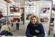 Marie Noëlle Gachet à un salon sur le cheval, dans son stand avec des poster sur le bien-être, l'équi-coaching, le handicap