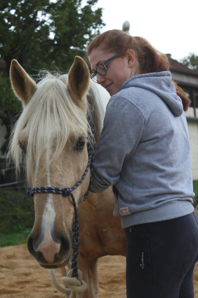 jeune femme caressant son cheval lors d'une séance de coaching